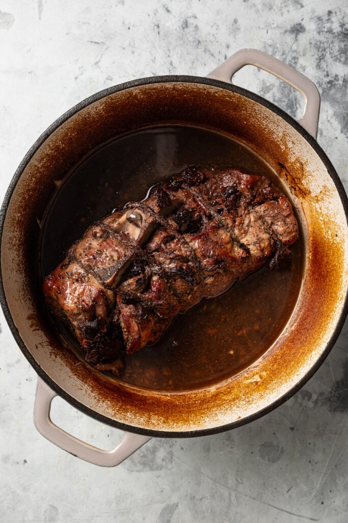 Roasted pork in the Dutch oven with its cooking juices. 