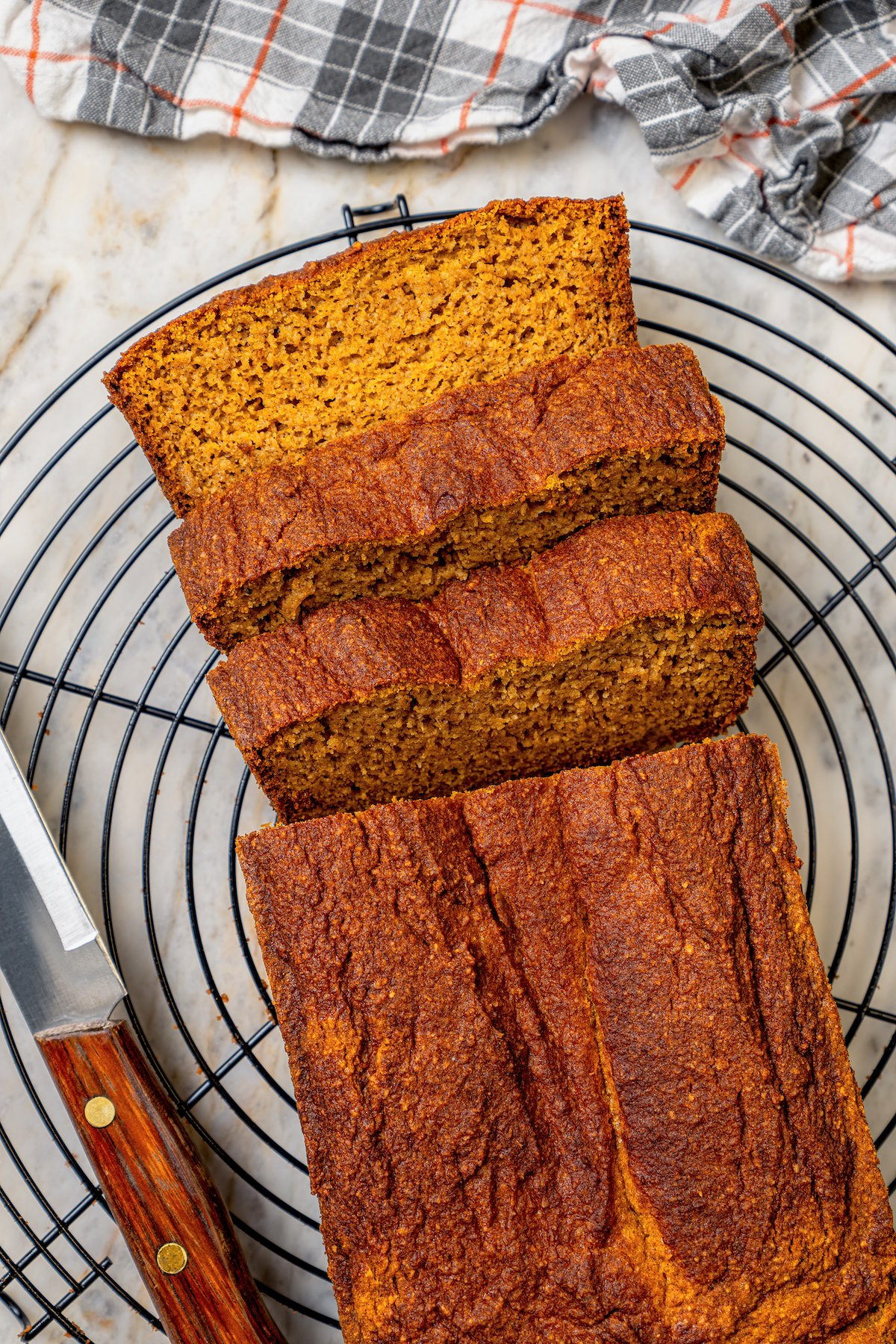 Sliced pumpkin loaf on a cooling rack.