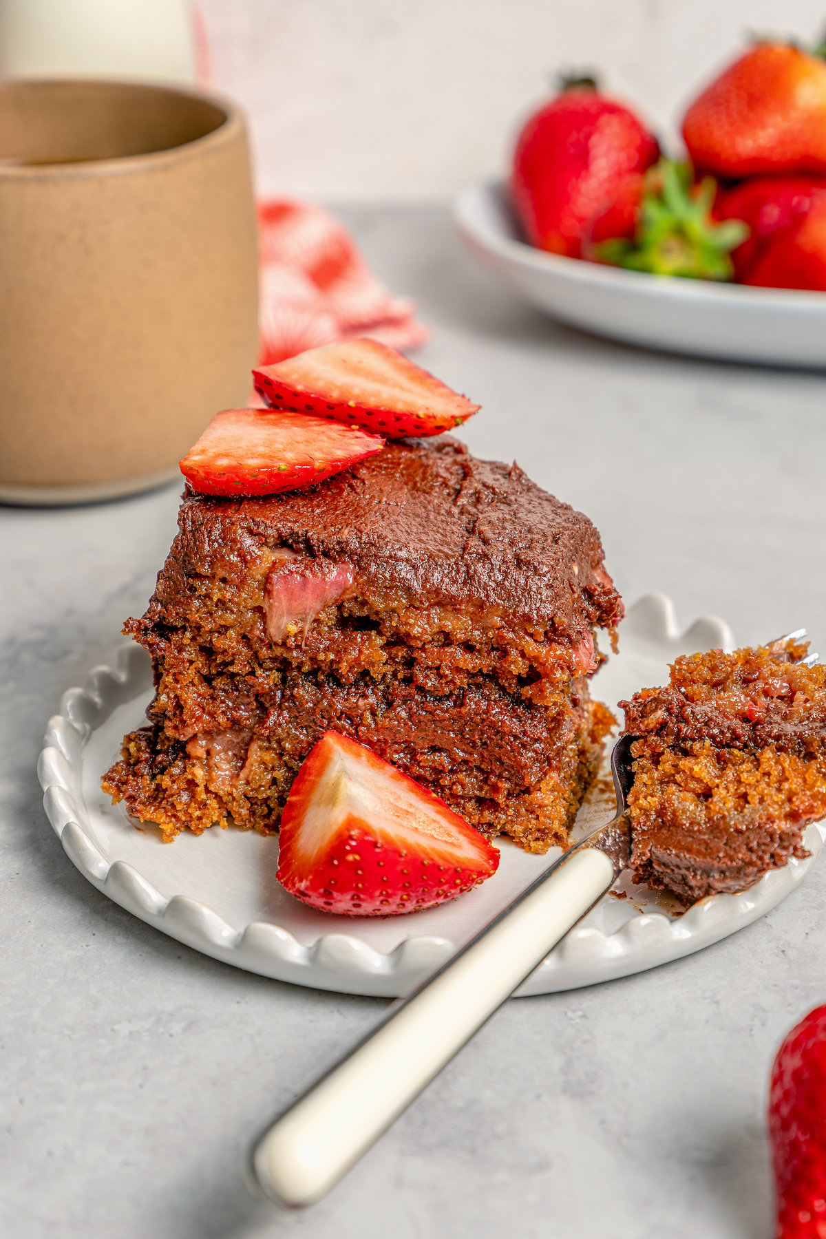 Digging into a slice of cake with chocolate frosting. 